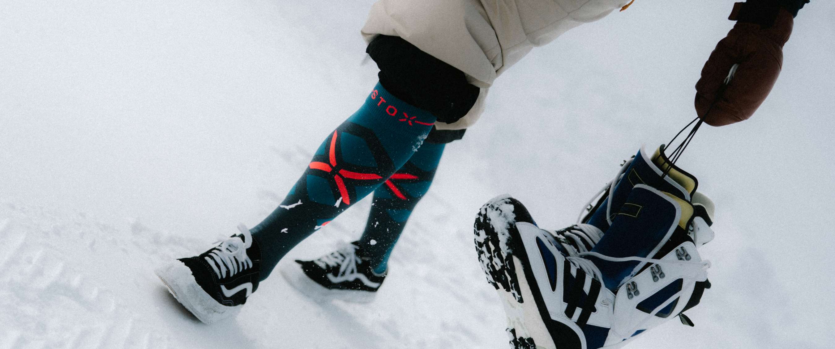 Close-up van benen in sneeuw met STOX technische wintersokken en schoenen