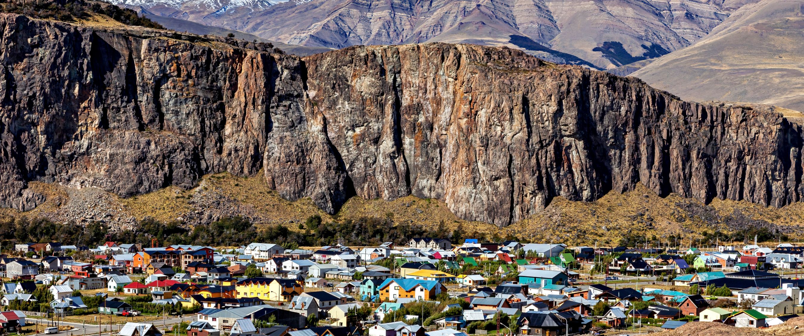 Kleurrijk bergdorp aan de voet van steile rotskliffen.