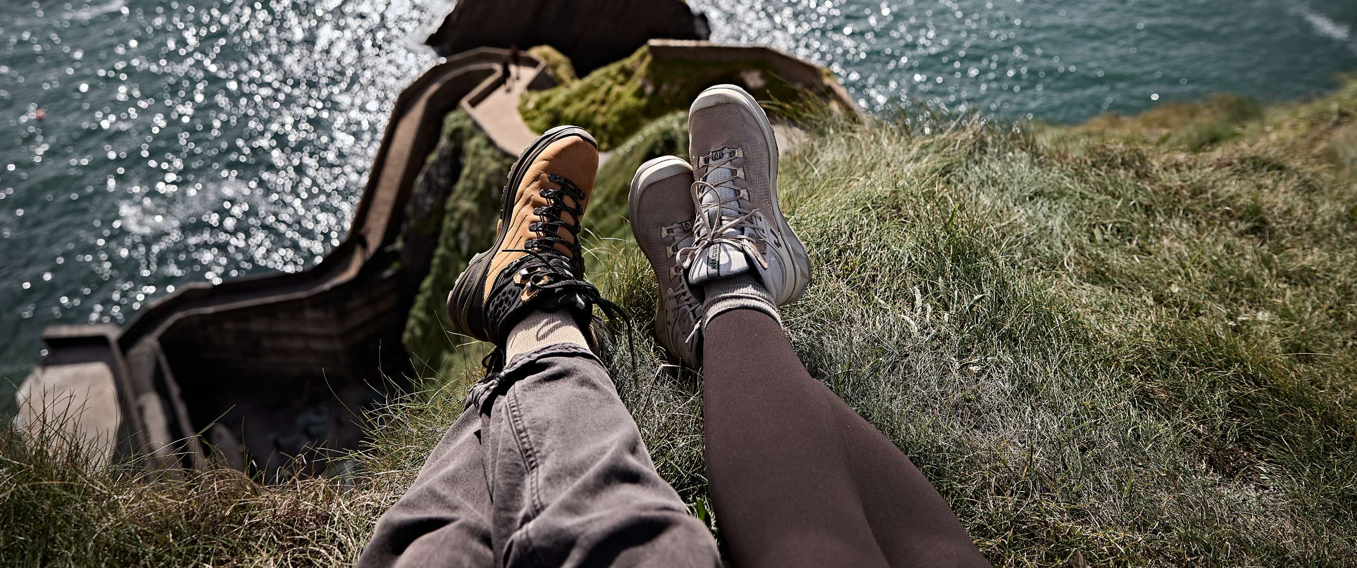 Deux images : Jambes avec chaussures de hiking sur bord herbeux avec vue sur l’eau et rochers.